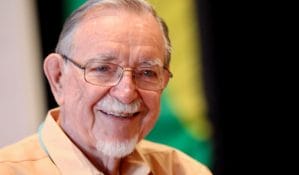 Photo of John McKnight - with white beard and mulash and glasses
